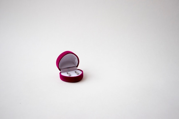 Czerwone aksamitne pudełko w kształcie serca ze srebrnymi kolczykami w środku, świąteczny prezent dla ukochanej