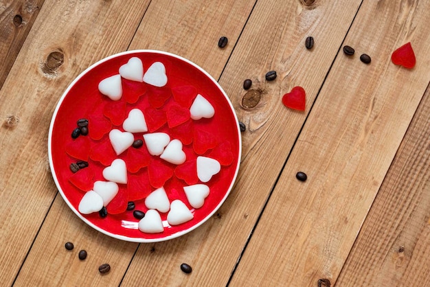 Czerwone cukierki w płytce w kształcie serca na drewnianym tle Walentynki Miejsce na tekst Widok z góry