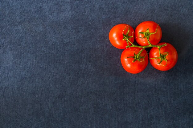 Czerwone cztery pomidory na niebieskim stole, warzywo