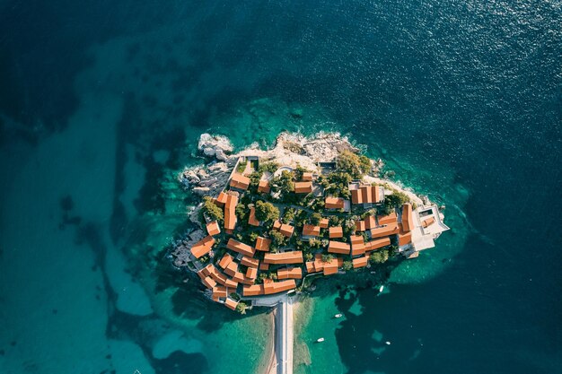 Czerwone dachy starożytnych domów na skalistej wyspie Sveti Stefan w zatoce Kotor Czarnogóra