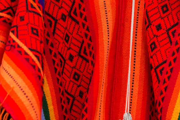 Czerwone i czarne wzory na niektórych ubraniach wykonanych z wełny lamy w sklepie z pamiątkami Cusco w Peru