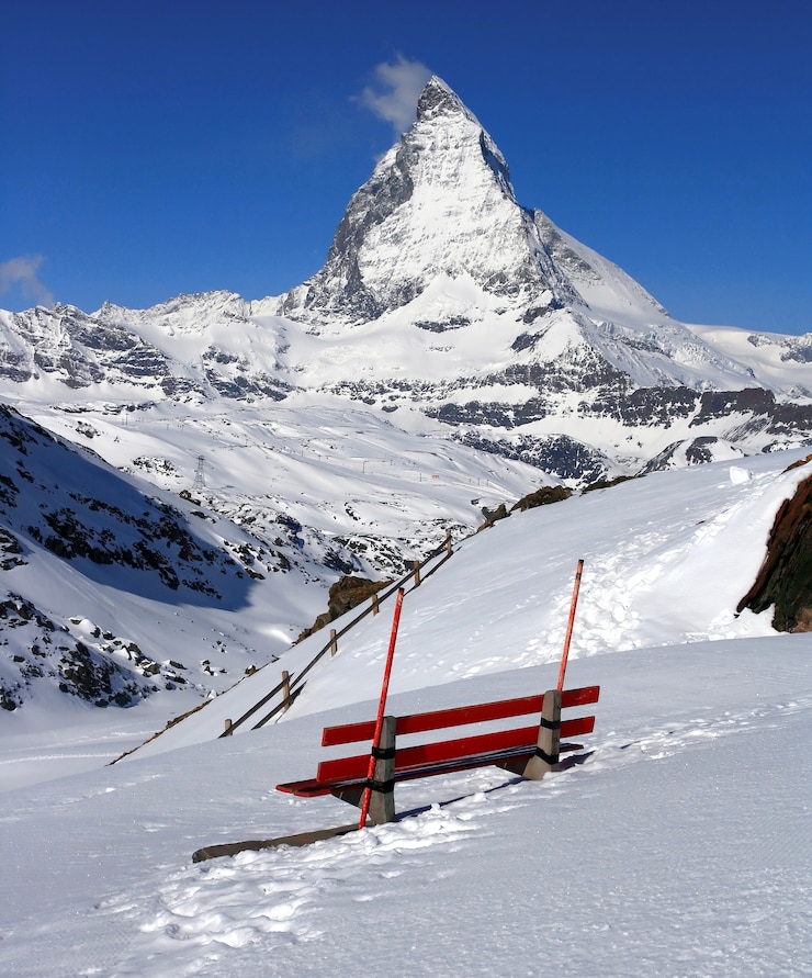 Zdjęcie czerwone krzesło i matterhorn, logo czekolady toblerone, z siedzibą w szwajcarii