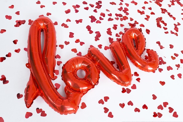 Czerwone litery Miłość na imprezę Walentynki i serca na białym tle, widok z góry.