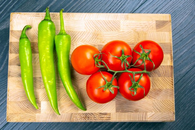 Zdjęcie czerwone pomidory i zielona ostra papryka na pokładzie kuchni