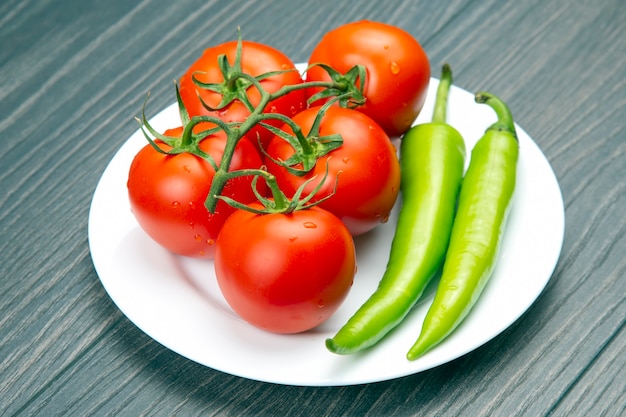 Czerwone pomidory i zielona ostra papryka na pokładzie kuchni