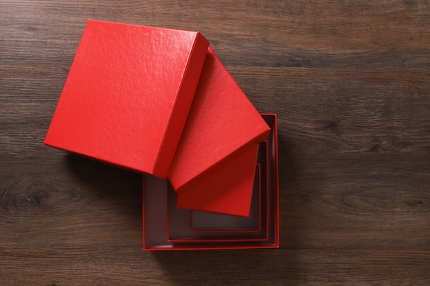 Czerwone pudełka na drewnianym stole.