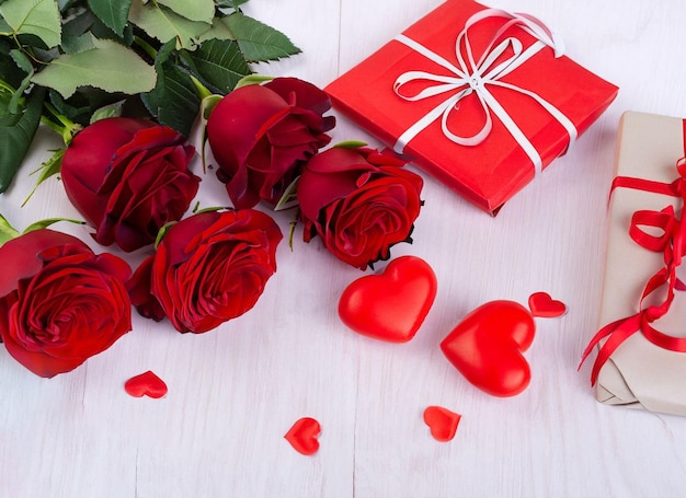 czerwone róże z ozdobnymi sercami i prezentami