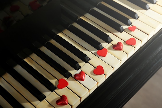 Czerwone serca na klawiszach fortepianu z bliska