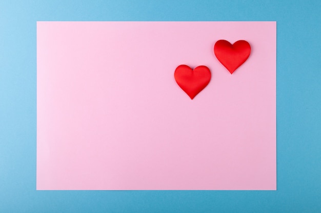 Czerwone serca na kolorowym tle, różowe w niebieskiej ramce, koncepcja kartki z życzeniami walentynkowymi
