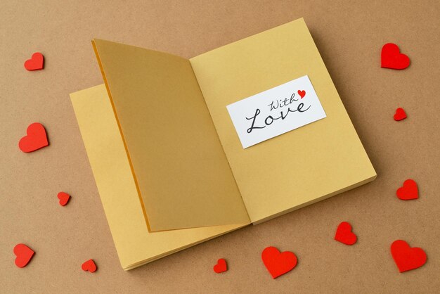 Zdjęcie czerwone serca, otwarta książka lub otwarty notatnik, karta z tekstem z miłością. wiadomość o miłości, koncepcja walentynki