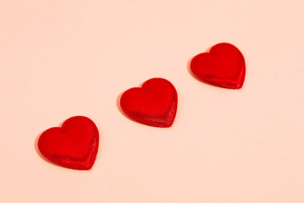 Czerwone serca są ułożone na różowym tle.
