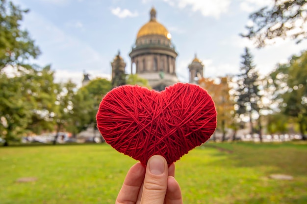 Czerwone serce w dłoni na tle soboru św. Izaaka w Petersburgu Rosja