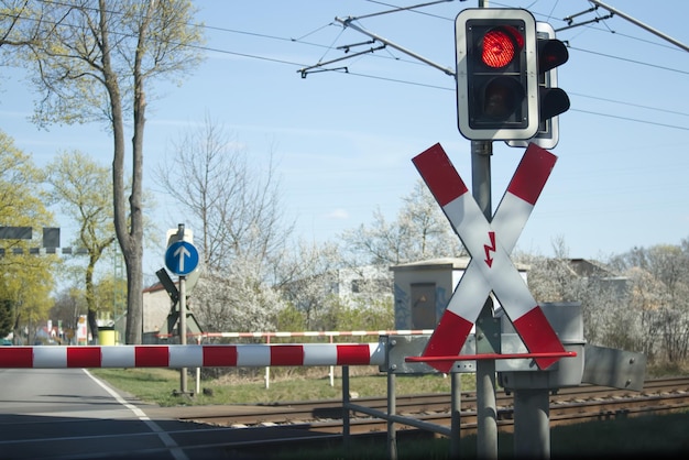 Czerwone światło przejazdu kolejowego i opuszczona barierka blokująca przejazd