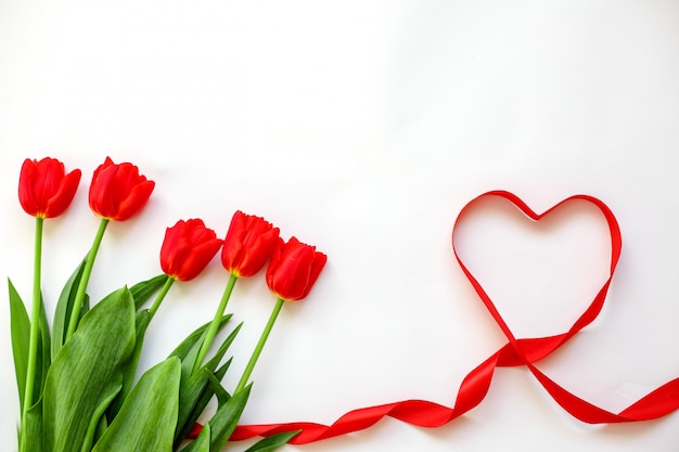 Czerwone tulipany i wstążka serca. Walentynki, dzień matki, ślub, dzień kobiet-koncepcja