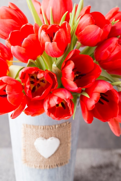 Czerwone tulipany na drewnianej powierzchni.