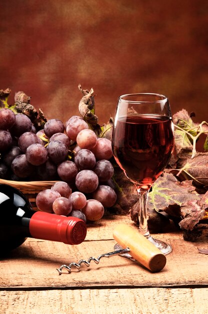 Czerwone wino podawane na drewnianych deskach z winogronami