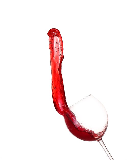 Czerwone wino rozpryskujące się ze szkła na białym tle
