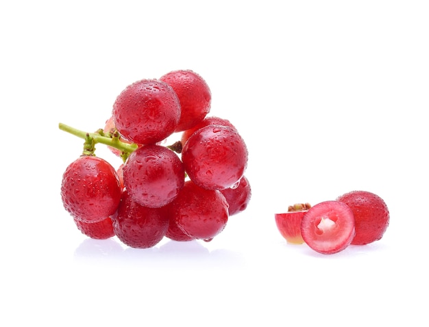 Czerwone winogrona i krople wody na białym tle