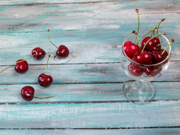 Zdjęcie czerwone wiśnie na drewnianym stole