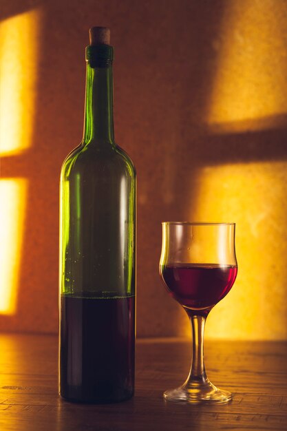 Czerwonego wina szkła blisko butelka na drewnianym stole