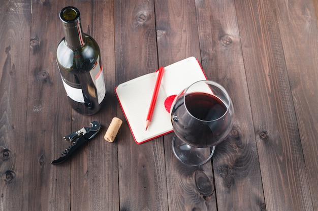 Zdjęcie czerwonego wina szkło i notatnik na stole