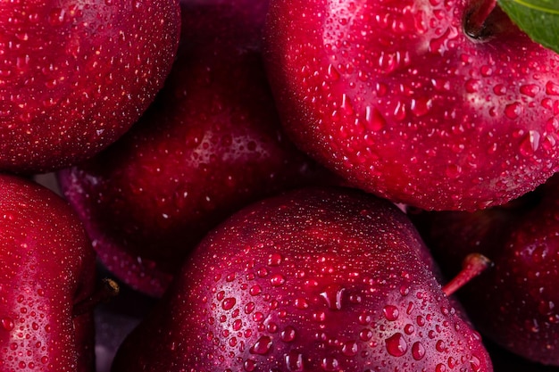 Zdjęcie czerwoni jabłka z liśćmi na stole