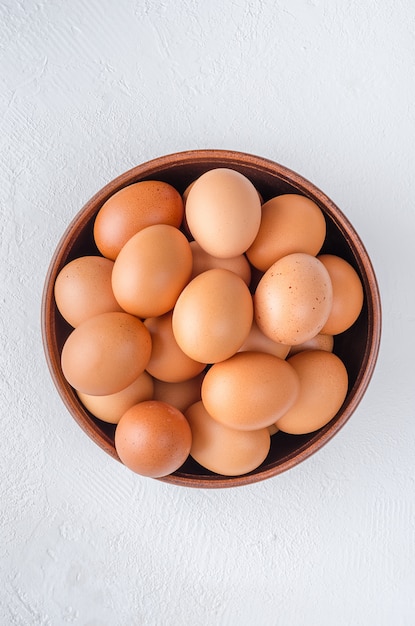 Czerwoni kurczaków jajka w glinianym pucharze