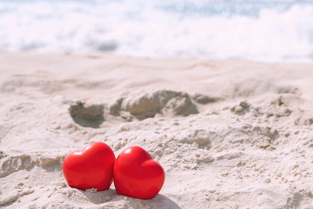 Zdjęcie czerwoni serca na tropikalnej plaży w słonecznym dniu