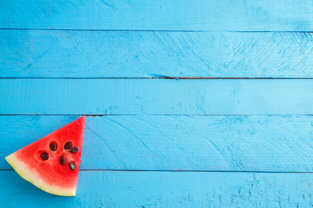 Zdjęcie czerwoni szkarłatni arbuzów kawałki na błękitnym drewnianym rocznika tle.