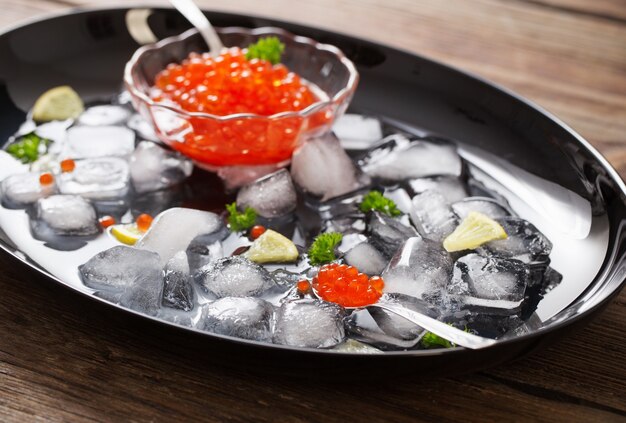 Czerwony carviar z lodem na czarnej płycie