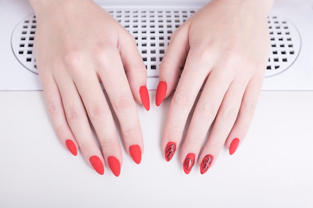 Czerwony Manicure Z Wzorem. Kobiece Ręce W Salonie Manicure
