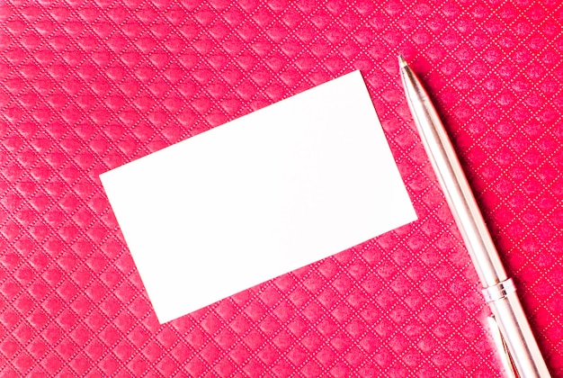 Zdjęcie czerwony notatnik na pulpicie pracownika biurowego, biała kartka papieru z miejscem na wstawienie pióra tekstowego skopiuj miejsce