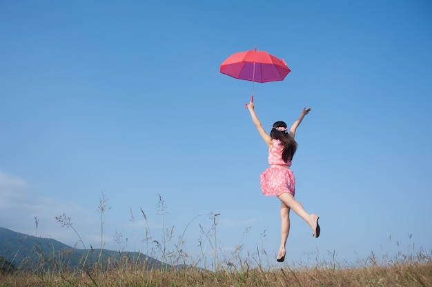 Czerwony parasol kobieta skok do nieba