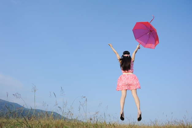 Czerwony parasol kobieta skok do nieba