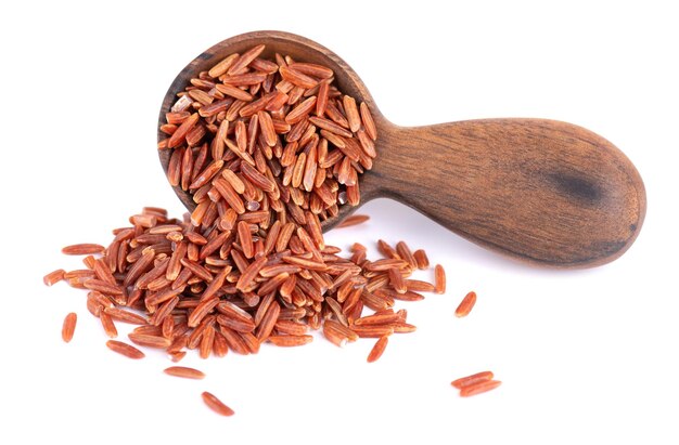 Czerwony ryż izolowany w drewnianej łyżce na białym tle Pełnoziarnisty surowy brązowy ryż
