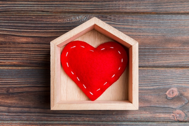 czerwony tekstylny serce w domu na drewnianym tle