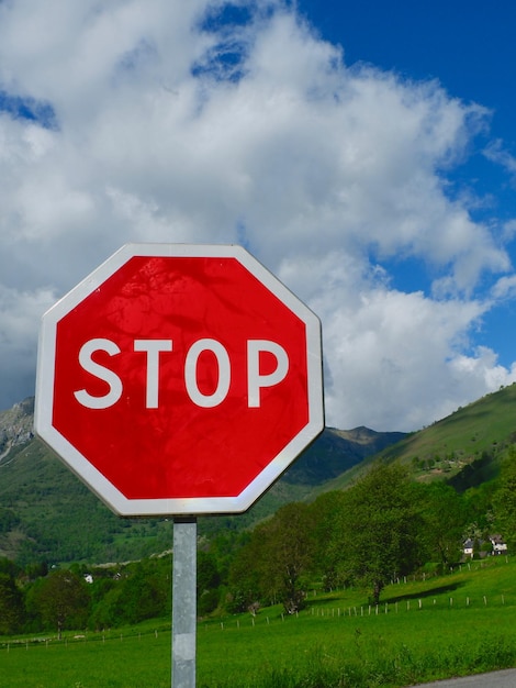 Czerwony znak stop na tle żywego górskiego krajobrazu w Accous France