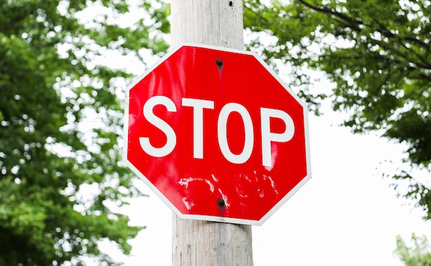Zdjęcie czerwony znak stopu na rogu ulicy miejskiej, symbolizujący bezpieczeństwo drogowe i przepisy ruchu drogowego jasne, niebieskie sk