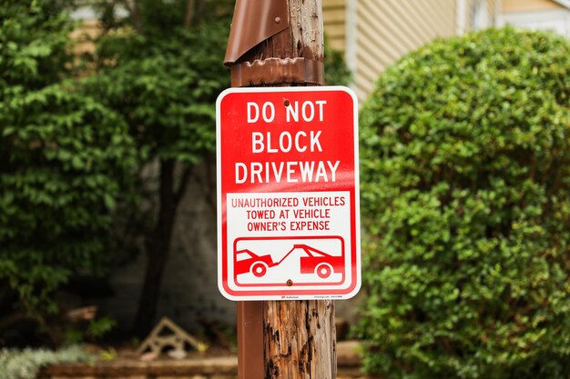 czerwony znak „Zakaz parkowania” oznacza obszary o ograniczonym dostępie, co oznacza przestrzeganie porządku i kontrolę ruchu, tj