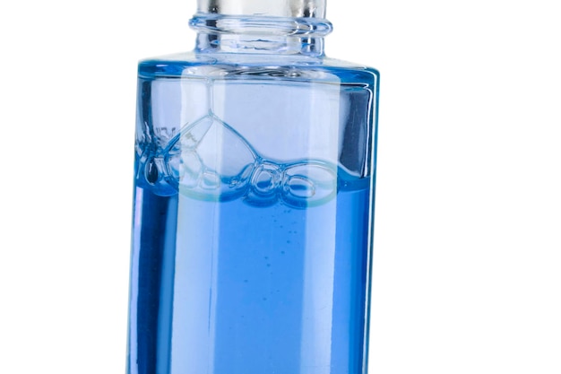Część butelki z niebieskim płynem kosmetycznym zbliżenie na białym tle