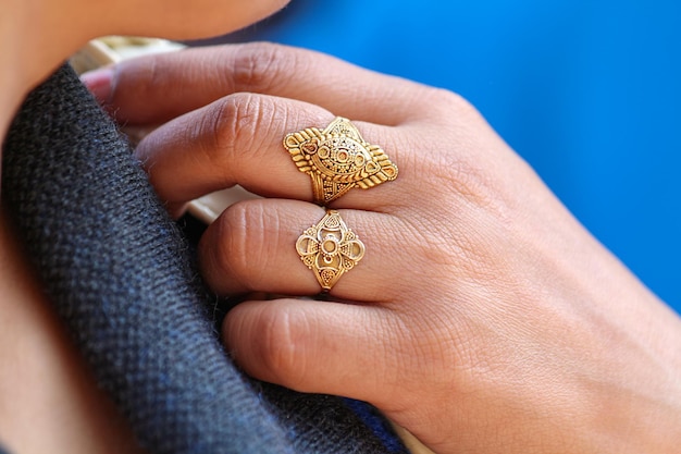 Część ciała - kobieca ręka. Złote indyjskie pierścienie na dłoni dziewczyny.