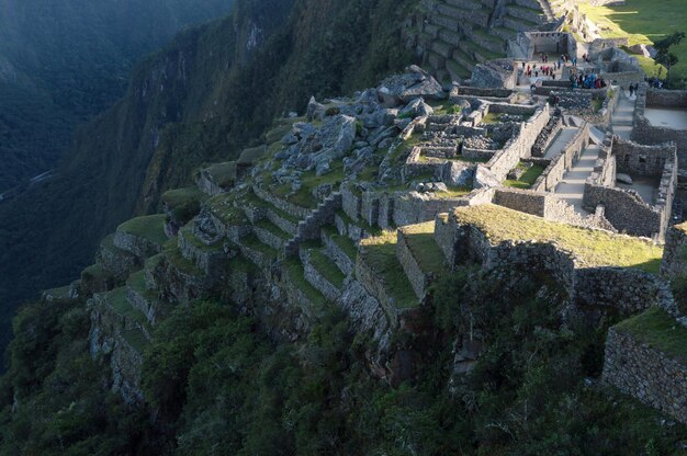 Część cytadeli Machu Pichu sfotografowana z góry, pokazująca budynki na krawędzi klifu