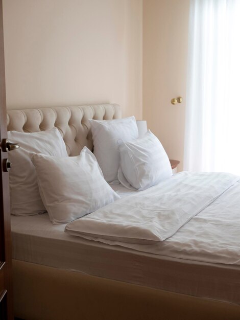 Zdjęcie część sypialna z nowoczesnym łóżkiem pokrytym śnieżnobiałą pościelą sypialnia wypełniona światłem