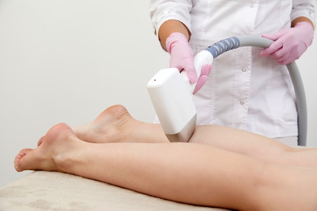 Częściowy widok kobiety otrzymującej depilację laserową na nodze w salonie