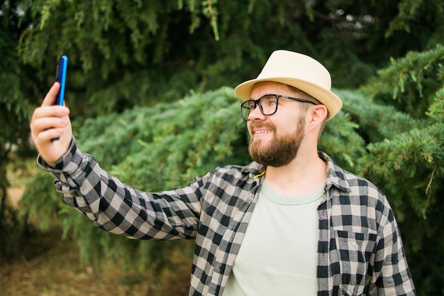 Człowiek Biorąc Selfie Portret Na Tle Drzewa Szczęśliwy Tysiącletni Facet Cieszący Się Letnimi Wakacjami W Cit