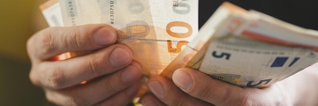 człowiek biznesu liczenia pieniędzy. bogate męskie dłonie trzymają i liczą banknoty 50 euro rachunki lub banknoty waluty. transparent