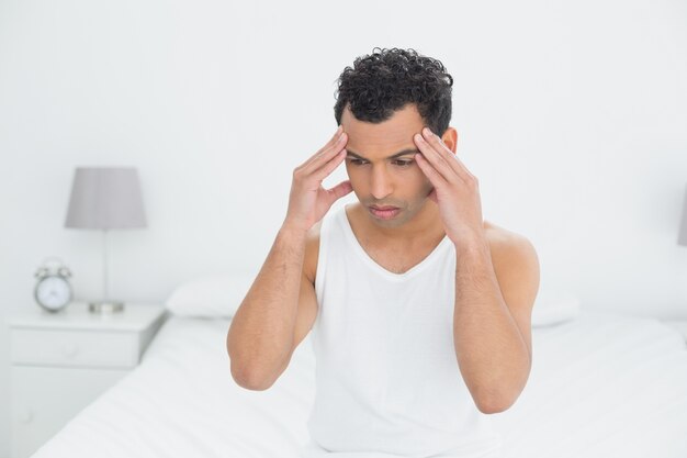 Człowiek cierpi na ból głowy w łóżku