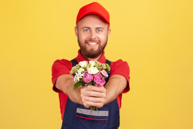 Człowiek Dostawy Daje Bukiet Kwiatów Przynosząc Porządek Patrząc Na Kamerę Z Radosnym Wyrazem Twarzy