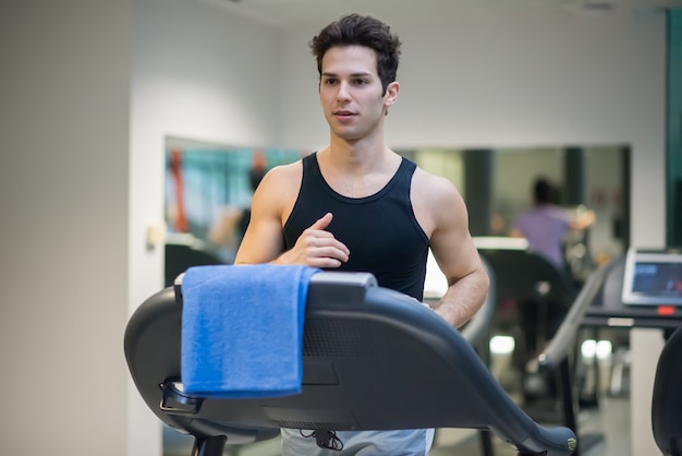 Człowiek działa na bieżni w siłowni, koncepcja treningu cardio