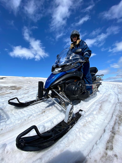 Zdjęcie człowiek na motocyklu na śniegu na tle nieba